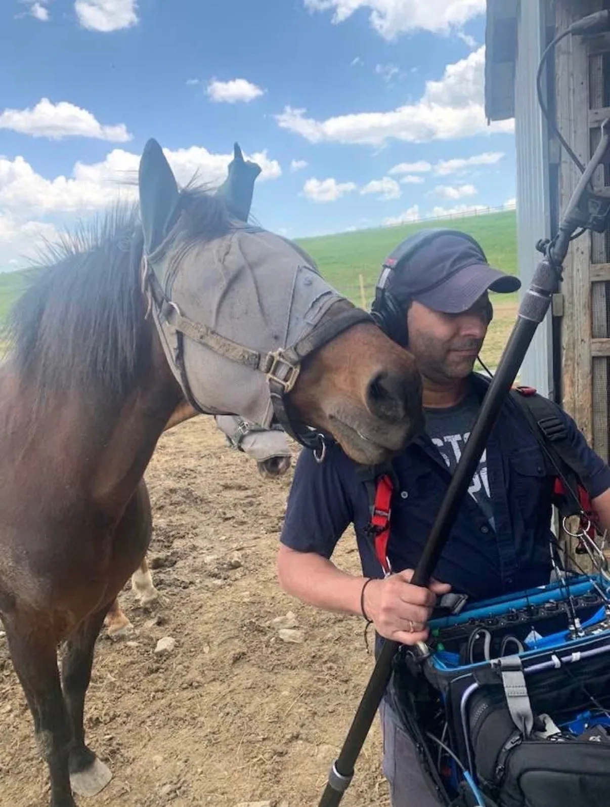 Matthew Legreca holding a boom microphone near a horse during a rural shoot