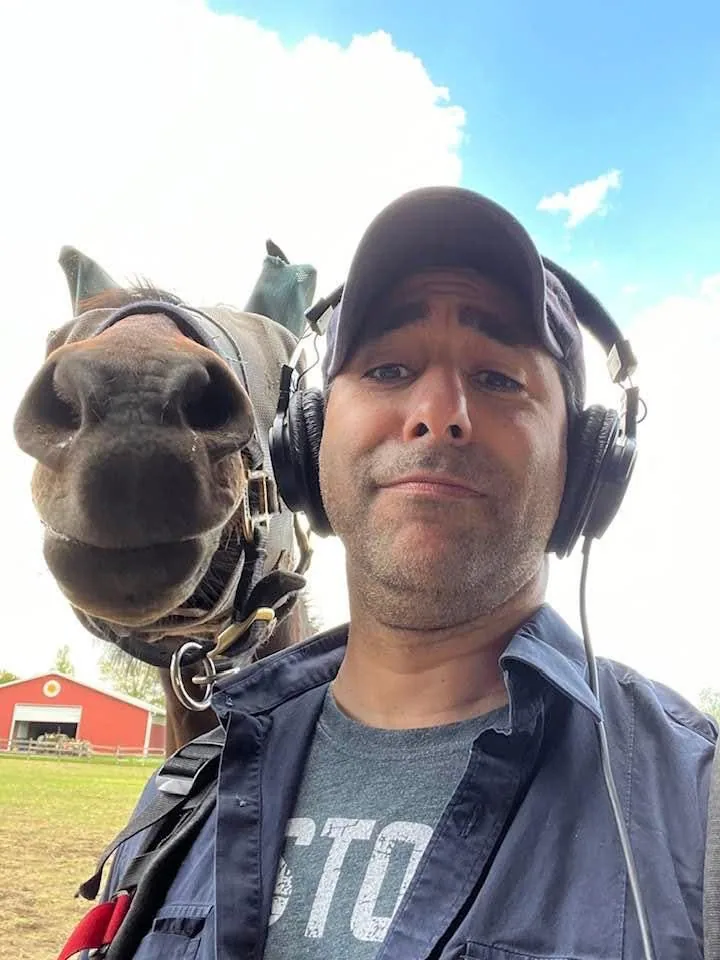 Matthew Legreca booming audio near sports mascots outside a stadium