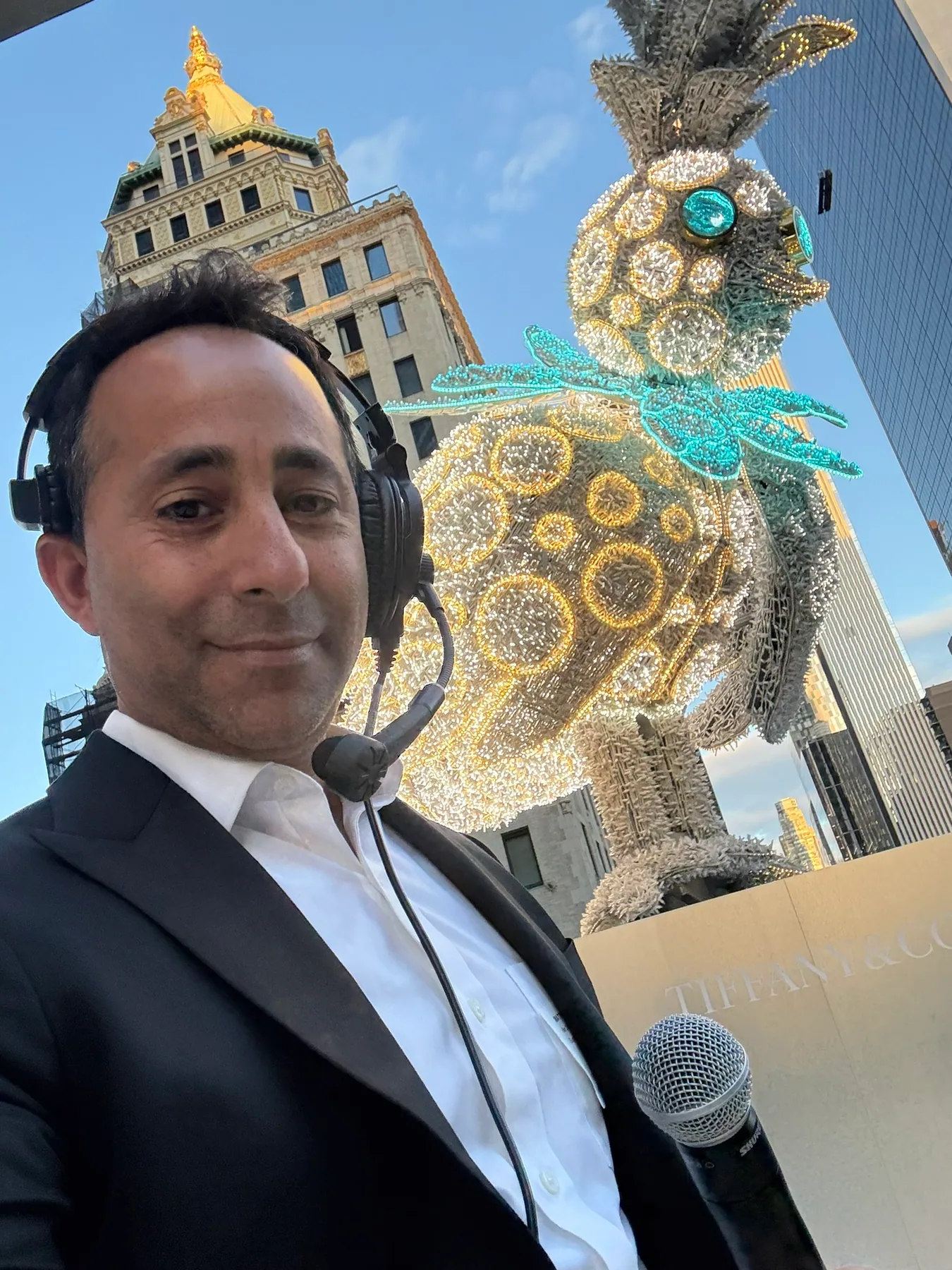 Matthew Legreca wearing a headset and holding a handheld microphone at an event