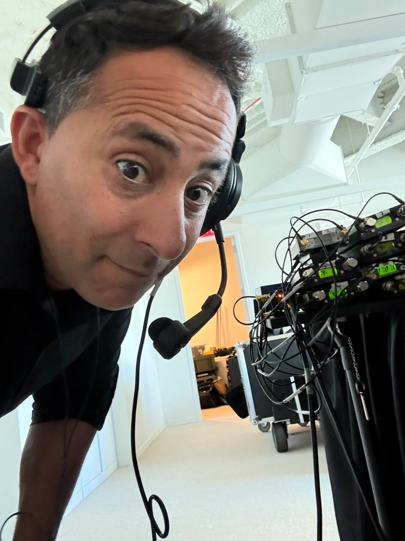 Matthew Legreca wearing a headset beside wireless audio receivers and cables